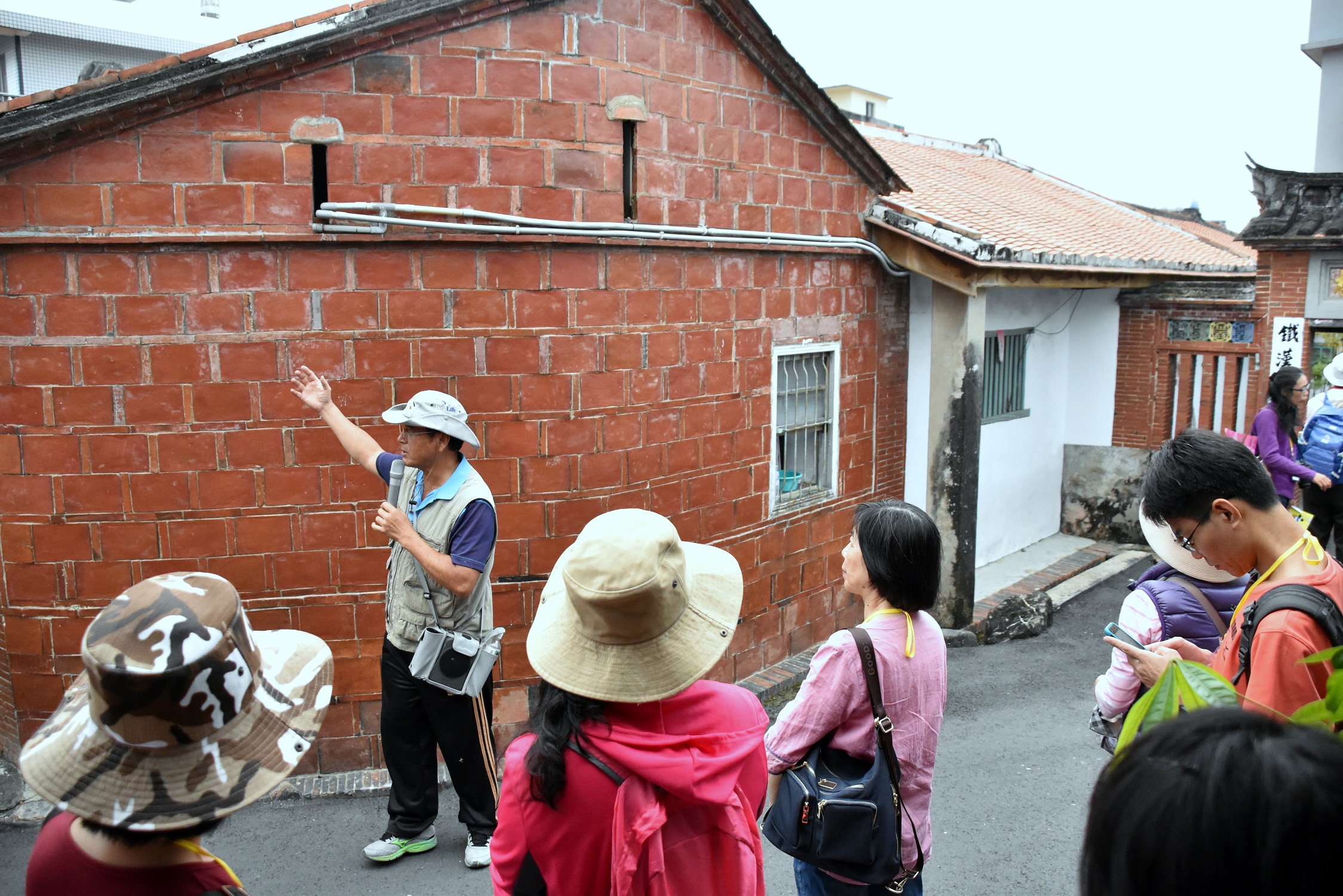 五溝社區發展協會總幹事李仲謙向學員說明客家建築槍眼由來.jpg