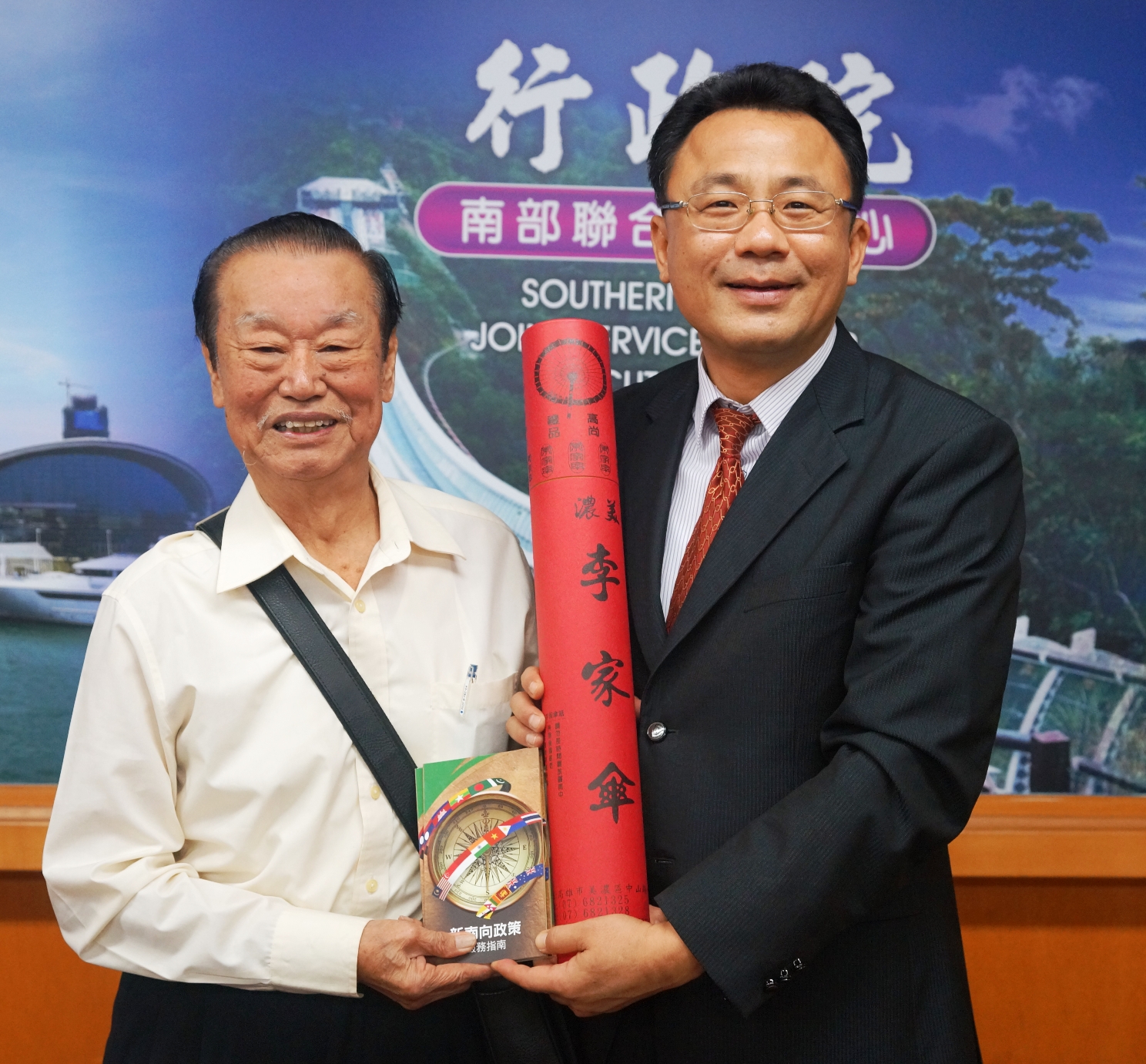 黃義佑執行長贈新南政策指南及客家紙傘給新加坡武吉班讓客屬公會會長郭俊堂